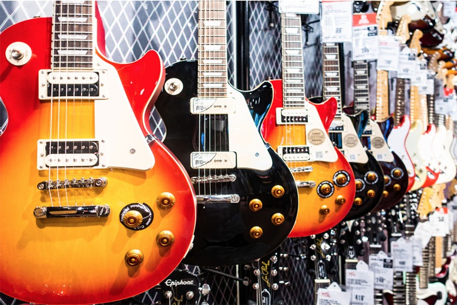 multiple guitars hanging on a wall